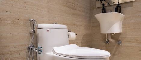 A modern bathroom with a toilet, shower, and sink.