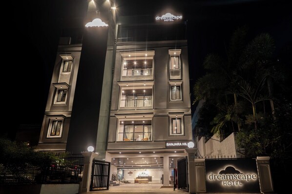A multi-story hotel with a modern facade, illuminated windows, and a prominent entrance. - Dreamscape by Fracspace (Hyderabad)