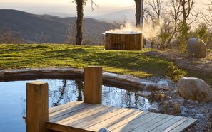 A wooden deck by a pond with a sauna in the background. - Between the mountains and the sea, a profound and eco-chic nature experience in (Montbolo)