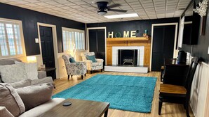 Un salon avec une cheminée, un tapis bleu et un canapé.