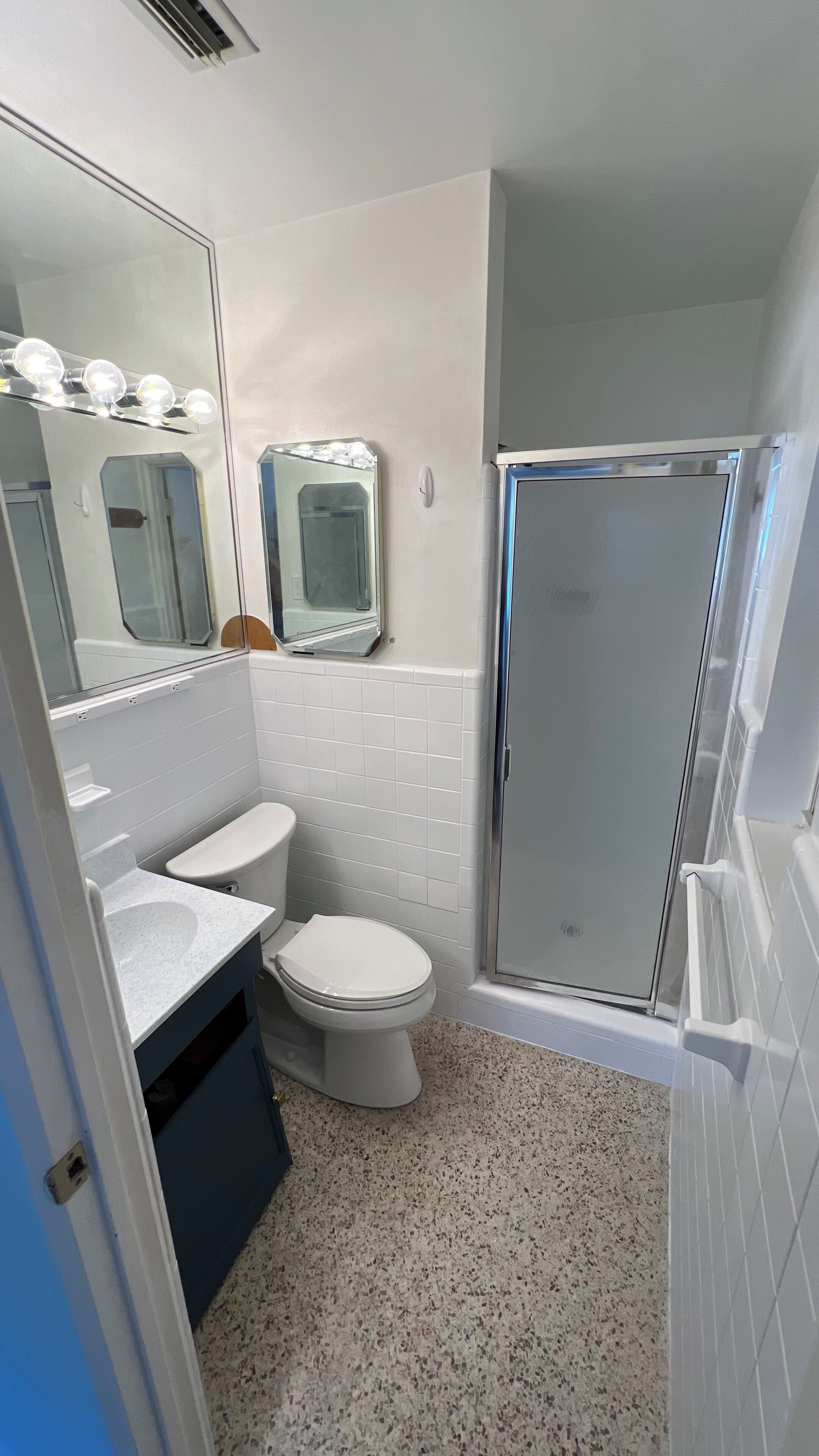 A bathroom with a toilet, sink, and shower.