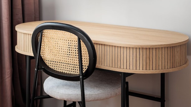 A dining area with a round wooden table, a black chair with a woven seat, and a framed picture on the wall. - Retro Glamour by Upstairs (Kraków)