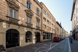 A street view with a building featuring arched windows and a sign for a spa. - Retro Glamour by Upstairs (Kraków)