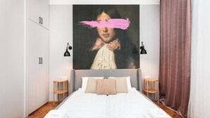 A bedroom with a large bed, two bedside tables, a wardrobe, and a painting on the wall. - Retro Glamour by Upstairs (Kraków)