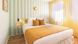 A hotel room with a bed, a bedside table, a lamp, and a window with curtains.