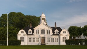 A large white building with a central tower, multiple windows, and a clock. - Spacious near-city villa with amazing views, 5BR, Free Parking (Vestland)