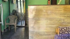 Une pièce avec un tapis bleu, un banc en bois, un canapé et une horloge murale.