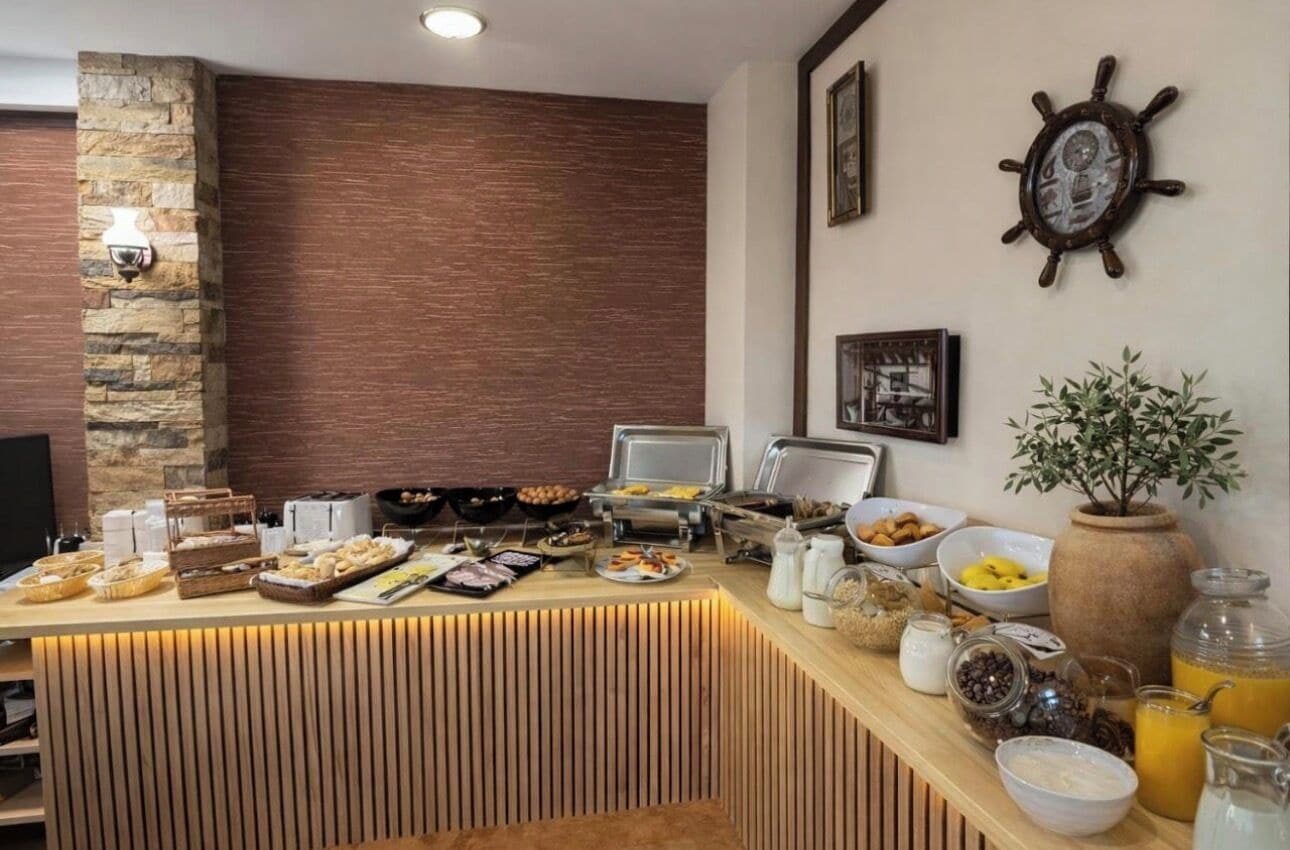 A breakfast buffet with various food items, a clock, and a decorative plant.
