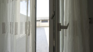 An open door with a view of a tiled floor and a building in the background. - GS Residence (Trani)