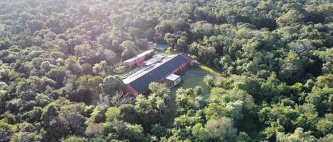 An aerial view of a large building surrounded by dense forest.