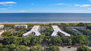 A coastal hotel with multiple buildings, a beach view, and a parking area. - Seaside Sanctuary - Villa Steps from Beach (Hilton Head Island)