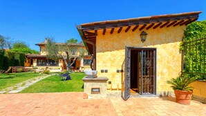 A traditional Mediterranean-style building with a tiled patio, a stone bench, and a potted plant. - La Valle Dei Casali B&B (Rome)