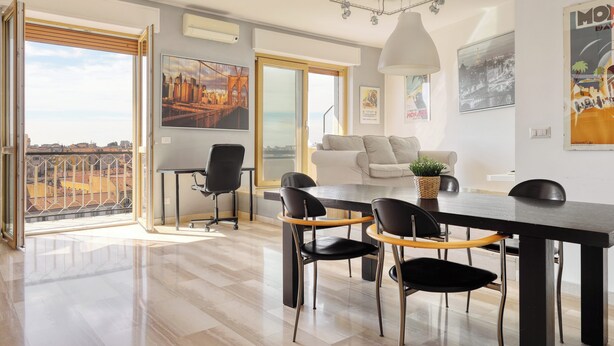 A modern dining area with a large table, chairs, and a view of the city. - Stylish 2BR flat next to Navigli (Milan)