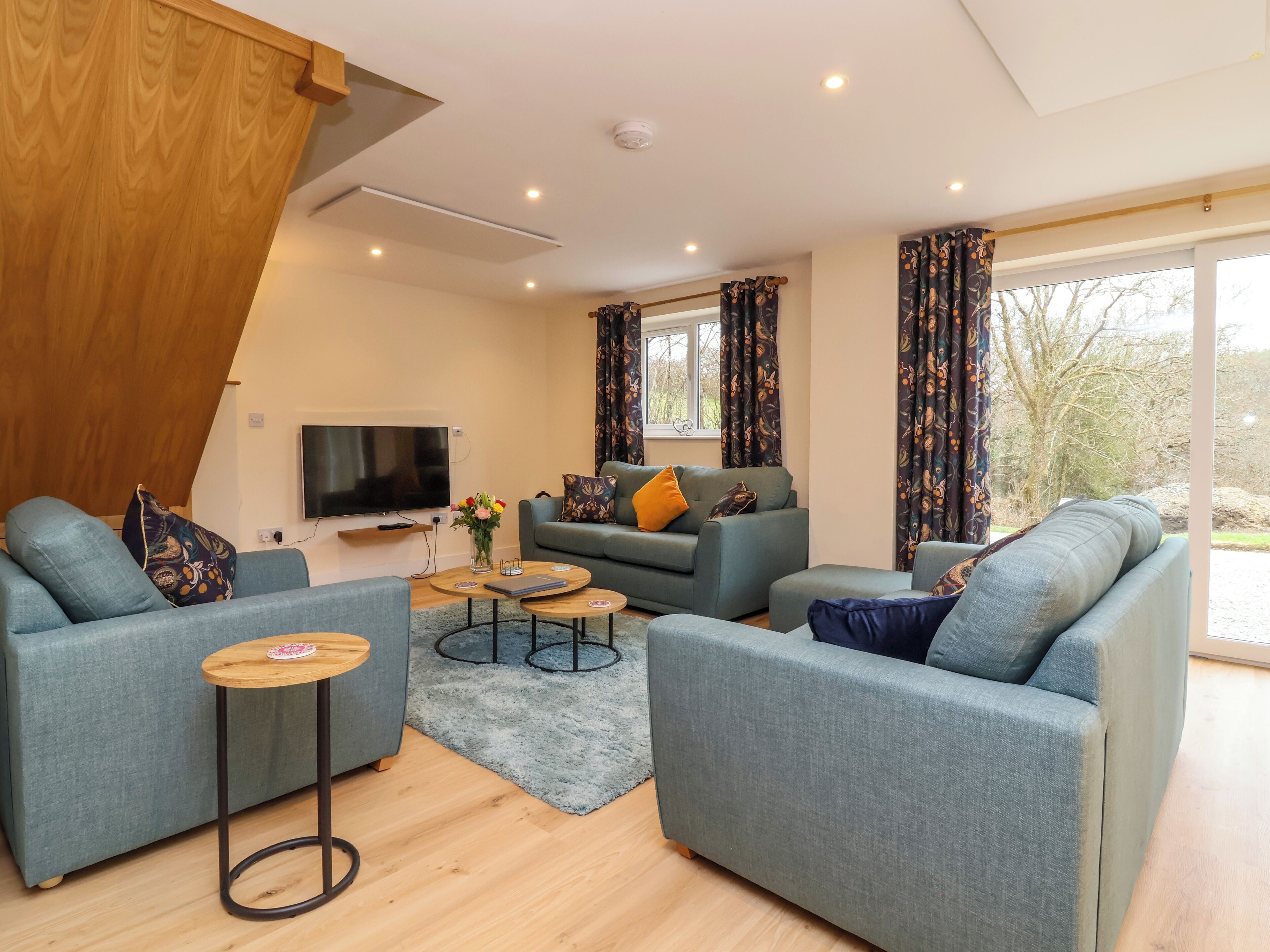 A modern living room with a sofa set, a coffee table, and a TV.