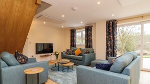 A modern living room with a sofa set, a coffee table, and a TV. - Hideaway (Torrington)
