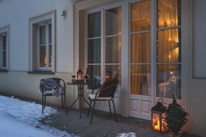 A cozy outdoor seating area with a table and chairs, a small Christmas tree, and a lantern. - Atrium   by Upstairs  (Kraków)