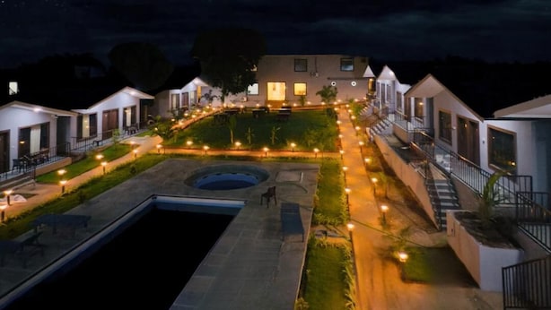 A modern hotel with a swimming pool, well-lit pathways, and a landscaped garden. -  Lampost Boutique Hotel  (Arambol)