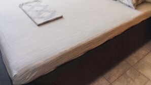 Una habitación de hotel con una cama grande, una mesita de noche con lámpara, un espejo y una obra de arte en la pared.