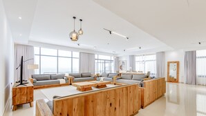 Un amplio salón con un sofá seccional de madera grande, una mesa de centro y un mueble para televisión.