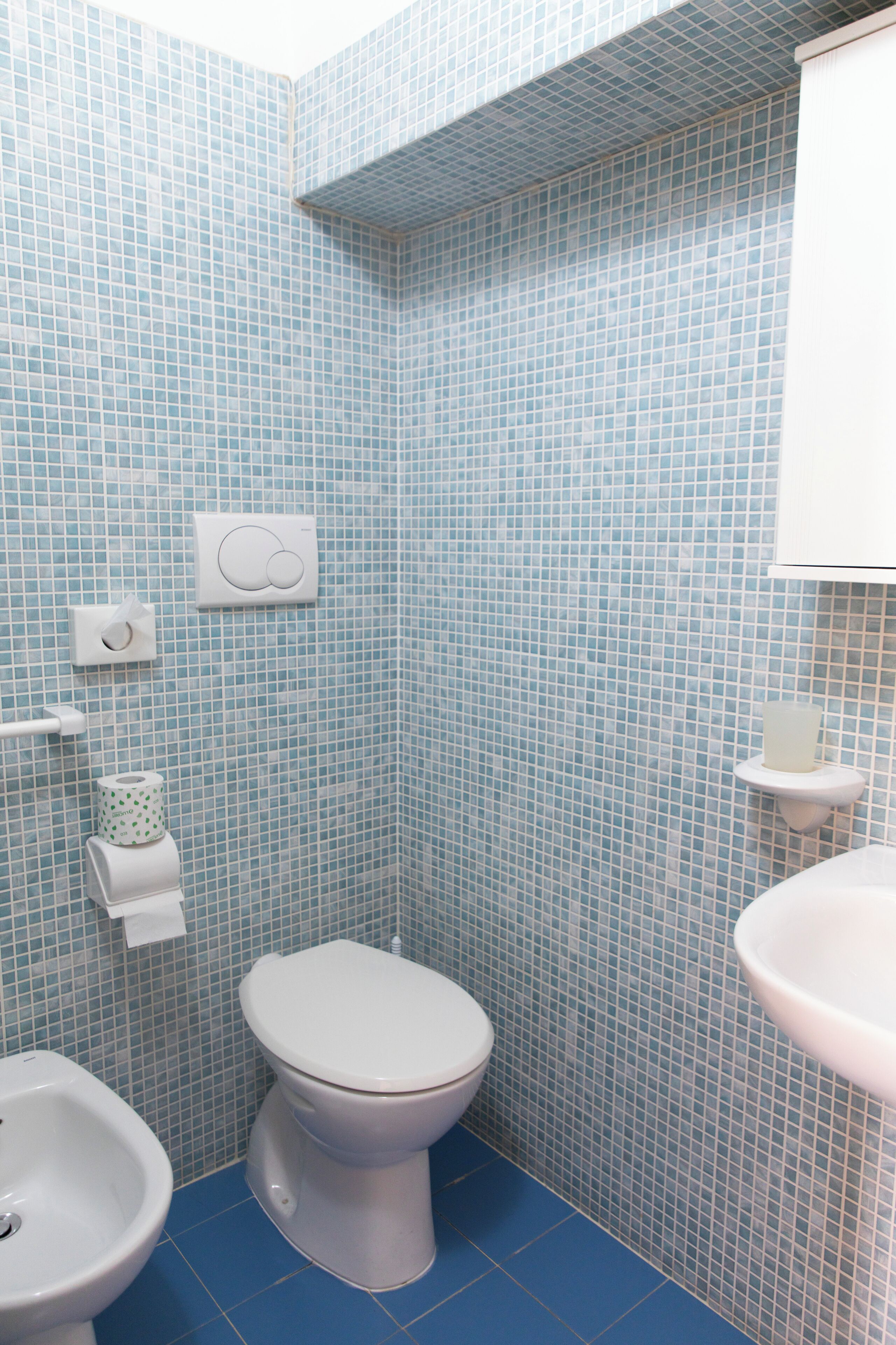Une salle de bain équipée de toilettes, d’un bidet et d’un lavabo.