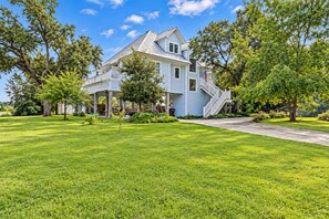 A two-story house with a covered porch and a staircase leading to the second floor. - Elegant Escape: Pool-Gourmet-Kitchen-Elevator (Long Beach)