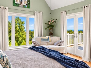 A bedroom with a large bed, a sofa, and a view of the outdoors. - Elegant Escape: Pool-Gourmet-Kitchen-Elevator (Long Beach)