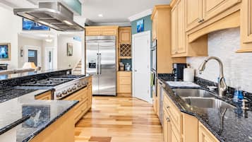 Una cocina moderna con un refrigerador de acero inoxidable, un horno empotrado y una encimera de granito.