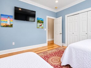 A bedroom with two beds, a TV, and artwork on the wall. - Elegant Escape: Pool-Gourmet-Kitchen-Elevator (Long Beach)