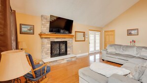 A living room with a fireplace, a television, a sofa, and a rocking chair. - Game Room & On-site Pond: Laurelville Retreat! (Laurelville)