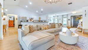 A spacious living room with a large sectional sofa, a round coffee table, and a chandelier. - Near Parks & Lakes: Sorrento Home w/ Pool & Yard! (Sorrento)