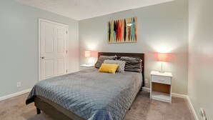 A bedroom with a bed, two bedside tables, a nightstand, a door, and a wall-mounted artwork. - 1 Mi to Dtwn: Pet-friendly Apt in Nashville (Nashville)