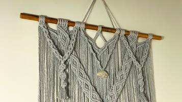 A macramé wall hanging with a wooden rod and tassels.