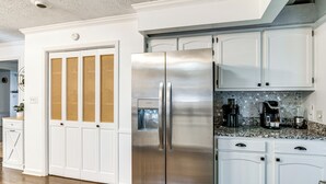 A modern kitchen with white cabinetry, a stainless steel refrigerator, and a coffee maker on the countertop. - 4 Mi to Wku: Hilltopper's Hideaway w/ Grills! (Bowling Green)