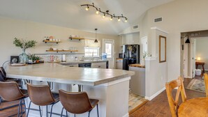 A spacious kitchen with a large island, bar stools, and modern appliances. - Creekside Cottage w/ Deck & Hot Tub in Belton (Belton)