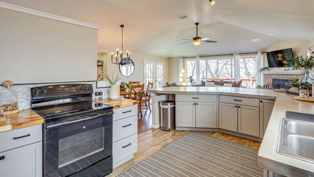 A modern kitchen with a large island, built-in oven, and a dining area with a view. - Creekside Cottage w/ Deck & Hot Tub in Belton (Belton)
