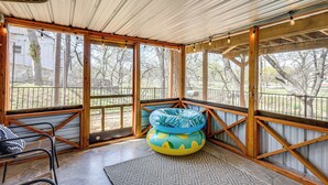 A covered outdoor seating area with a view of the yard, a wooden bench, and a patterned rug. - Creekside Cottage w/ Deck & Hot Tub in Belton (Belton)