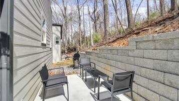 A patio with outdoor furniture and a stone wall.