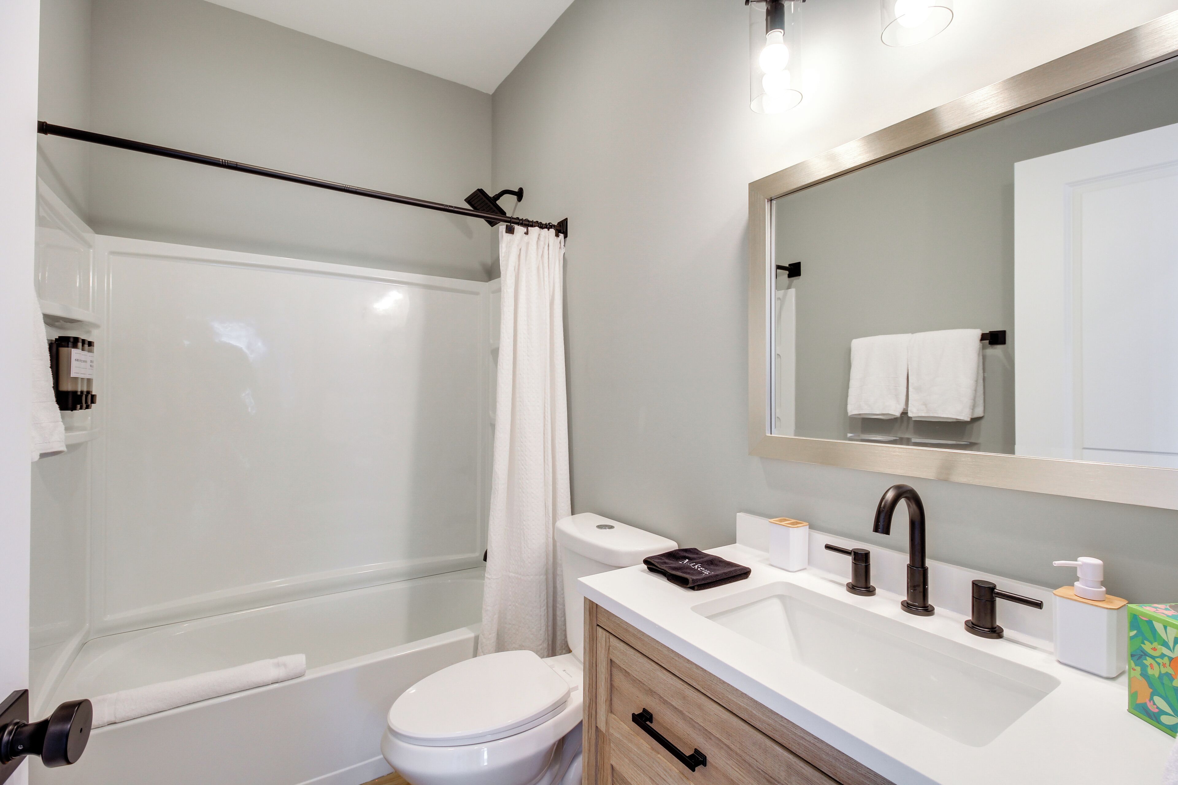 A modern bathroom with a bathtub, toilet, and sink.
