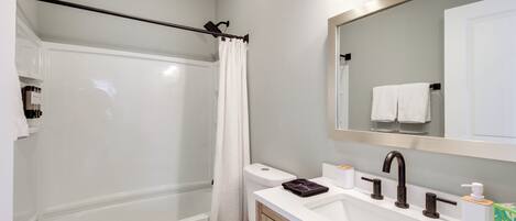 A modern bathroom with a bathtub, toilet, and sink.