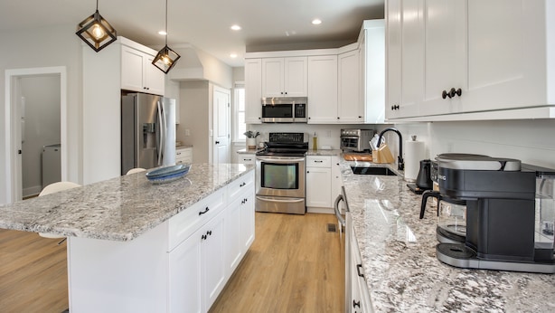 A modern kitchen with white cabinets, granite countertops, stainless steel appliances, and pendant lighting. - 6 Mi to Chattanooga: Home w/ Balcony & Dtwn Views! (Rossville)
