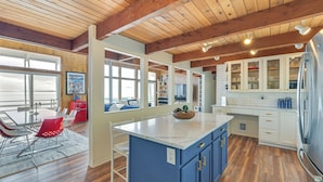 A spacious kitchen with wooden beams, a large island, and white cabinetry. - Decks & Views: Waterfront Shelton Home (Shelton)