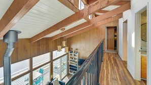 A wooden interior with a high ceiling, a staircase, and a view through large windows. - Decks & Views: Waterfront Shelton Home (Shelton)