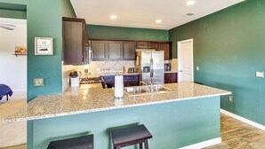 A kitchen with teal walls, granite countertops, and stainless steel appliances. - Shop, Dine & Unwind: Pet-friendly Home in Austin! (Austin)