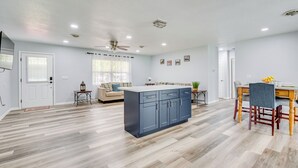 A modern kitchen with a central island, wooden flooring, recessed lighting, and a ceiling fan. - Stay & Play in Belleview: Welcoming Home w/ Yard (Belleview)