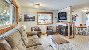 Una sala de estar acogedora con sofá, sillones, chimenea y televisor.