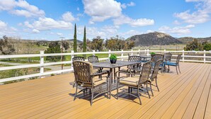 A wooden deck with a white fence, outdoor furniture, and a view of hills and trees. - Near Ramona Wineries: Mtn-view Haven w/ Large Yard (Ramona)