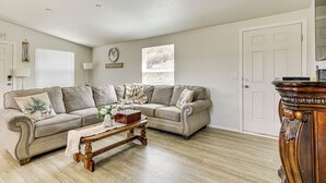 A living room with a beige sectional sofa, a wooden coffee table, and a wooden sideboard. - Near Ramona Wineries: Mtn-view Haven w/ Large Yard (Ramona)