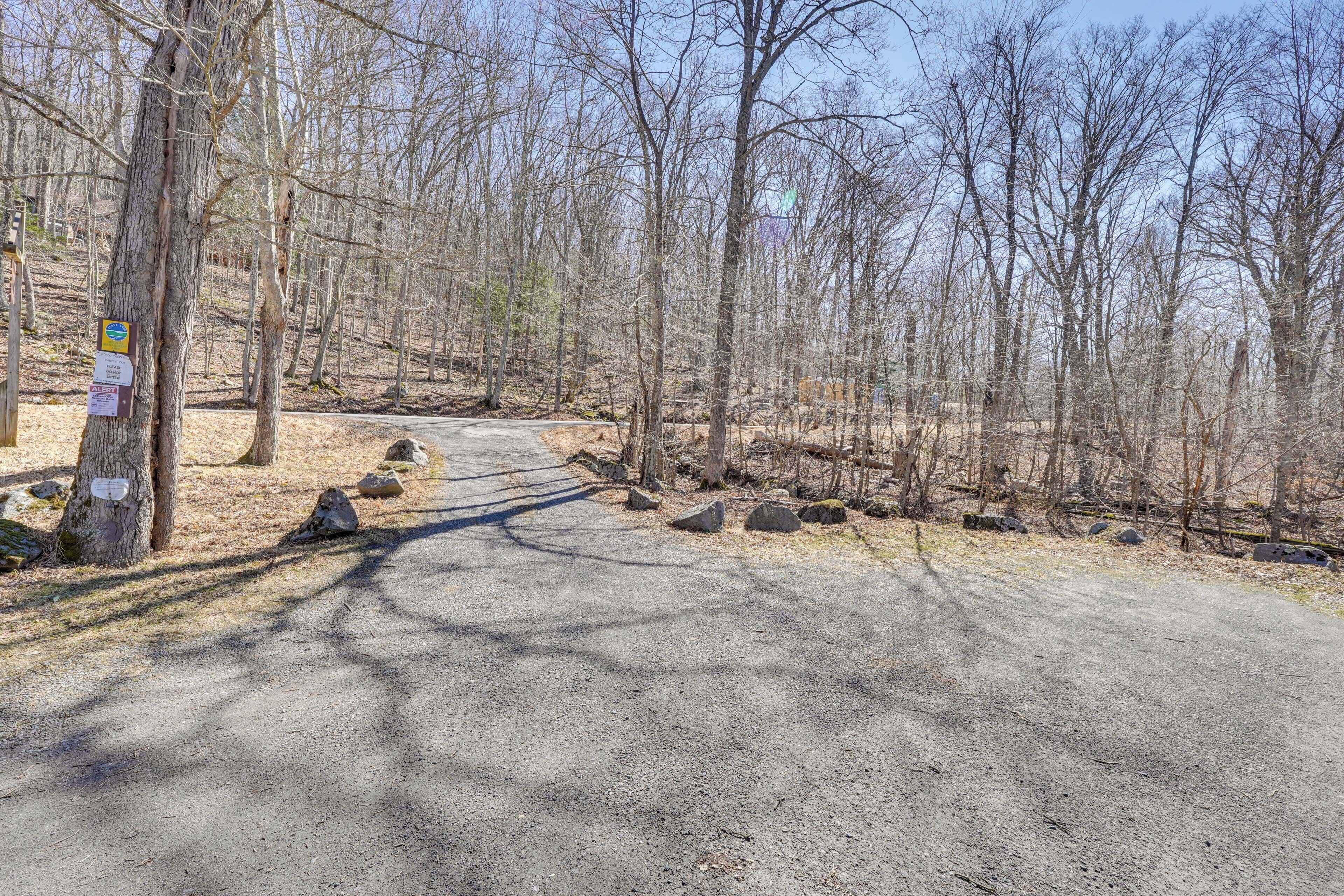 A paved road with a natural landscape, including trees and rocks.