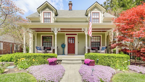 A two-story house with a front porch, a red door, and an American flag. - Walk to Main St & Parks: Zionsville Village Home (Zionsville)