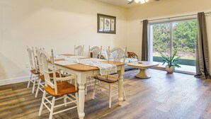 A dining area with a wooden table and chairs, a ceiling fan, and a window with curtains. - 11 Mi to Fort Myers River District: Suburban Haven (Lehigh Acres)